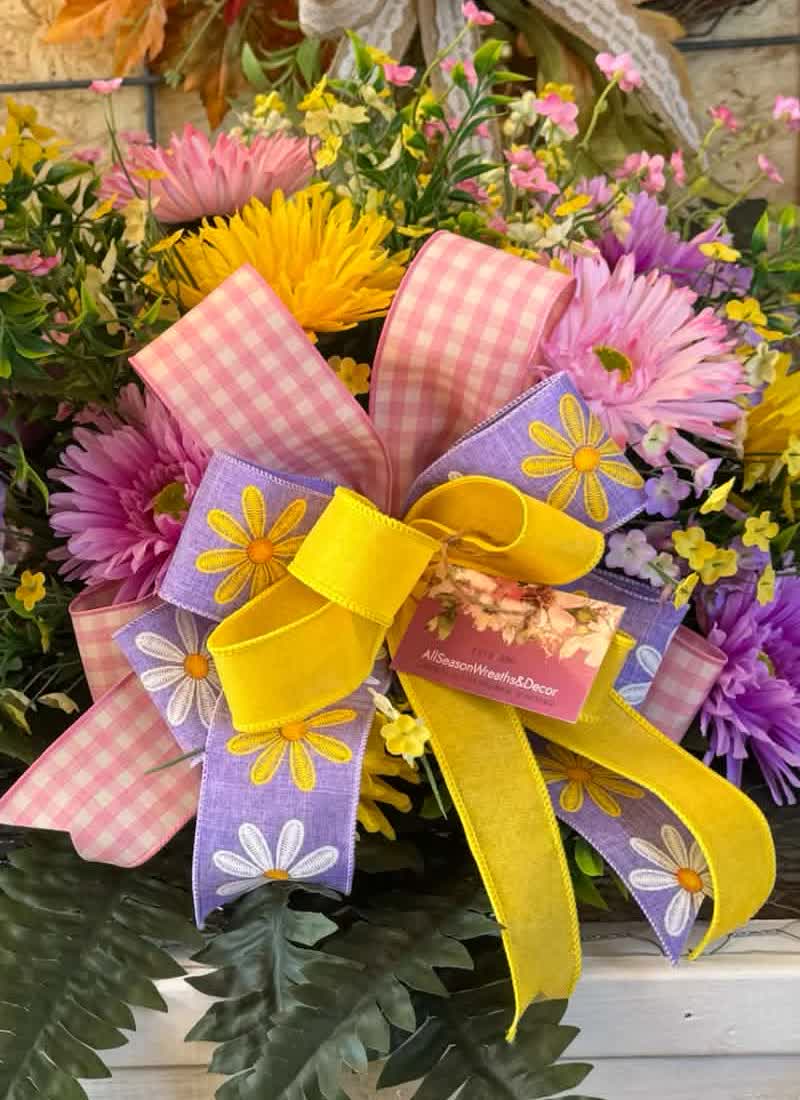 A headstone saddle arrangement in spring colors, shaped to sit across the top of the stone.