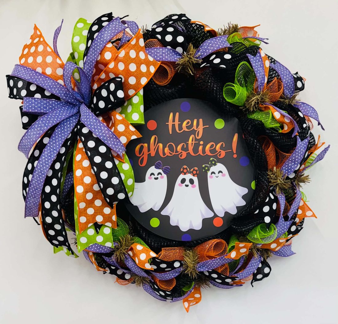 A 'Hey Ghosties!' sign with three smiling ghosts in bows, ringed by purple, orange, lime, and black polka-dot ribbons on black deco mesh.