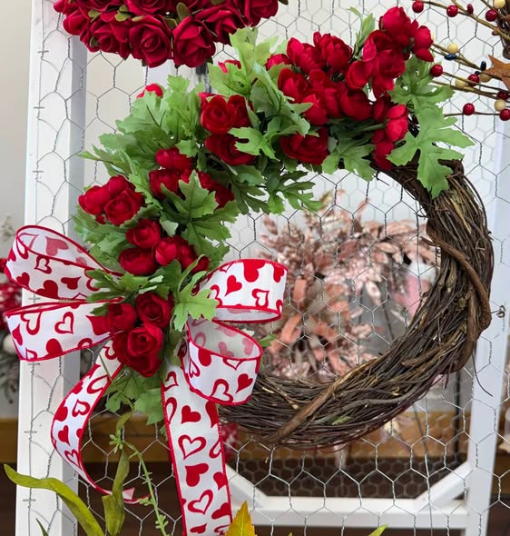 Valentine grapevine wreath wrapped in red roses with a heart-print ribbon.